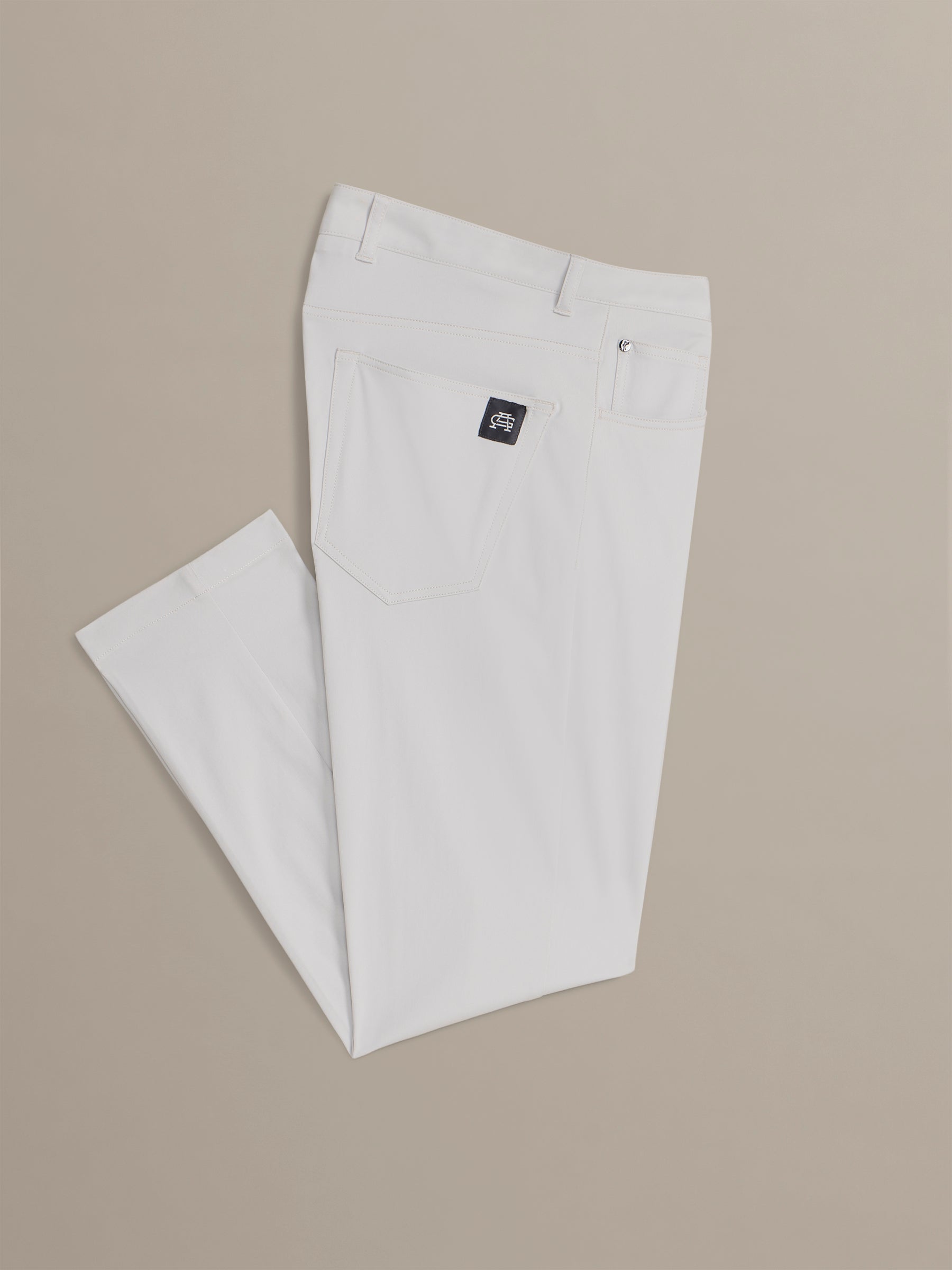 Light gray pants with a brand logo on a beige background